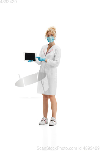 Image of Portrait of female doctor, nurse or cosmetologist in white uniform and blue gloves over white background