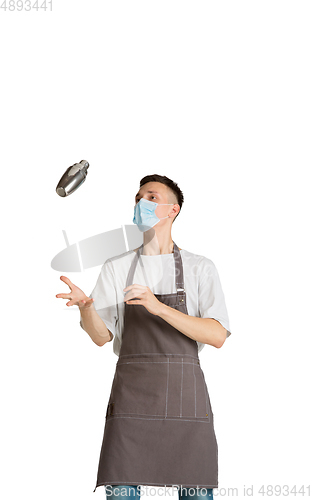 Image of Isolated portrait of a young male caucasian barista or bartender in brown apron smiling