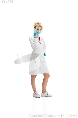 Image of Portrait of female doctor, nurse or cosmetologist in white uniform and blue gloves over white background