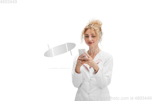 Image of Portrait of female doctor, nurse or cosmetologist in white uniform and blue gloves over white background