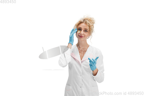 Image of Portrait of female doctor, nurse or cosmetologist in white uniform and blue gloves over white background