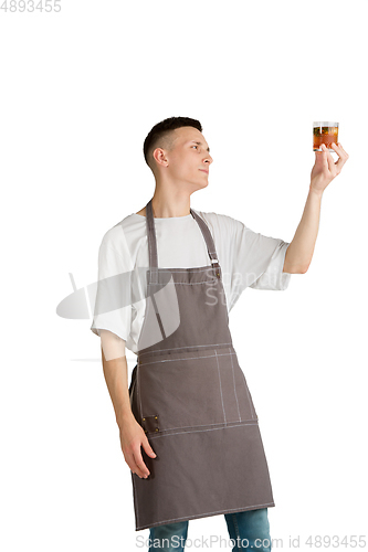 Image of Isolated portrait of a young male caucasian barista or bartender in brown apron smiling