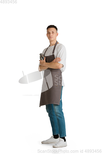 Image of Isolated portrait of a young male caucasian barista or bartender in brown apron smiling