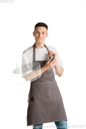 Image of Isolated portrait of a young male caucasian barista or bartender in brown apron smiling