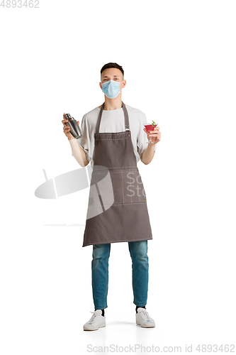 Image of Isolated portrait of a young male caucasian barista or bartender in brown apron smiling