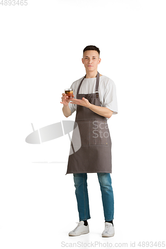 Image of Isolated portrait of a young male caucasian barista or bartender in brown apron smiling