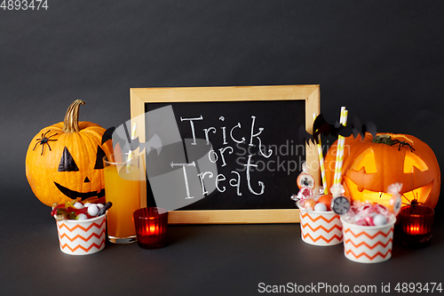 Image of pumpkins, candies and halloween decorations