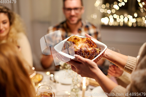 Image of happy friends having christmas dinner at home