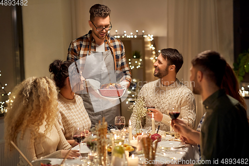 Image of happy friends having christmas dinner at home