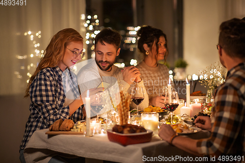 Image of friends with cellphone having dinner party at home