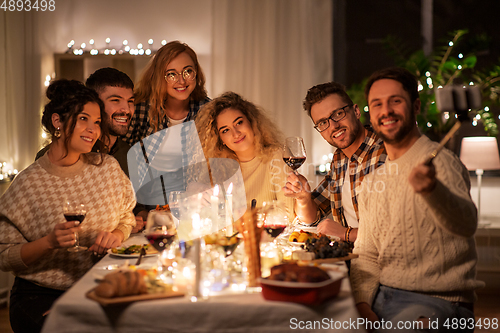 Image of friends taking selfie at christmas dinner party