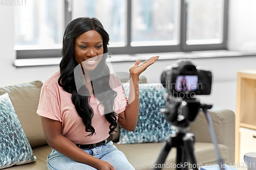 Image of female blogger with camera video blogging at home