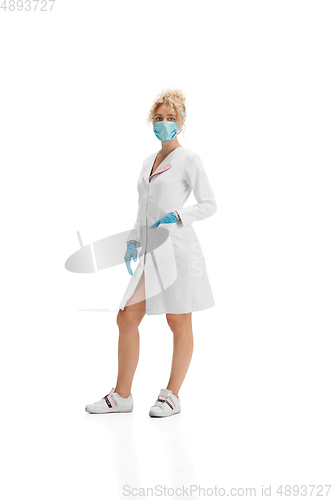 Image of Portrait of female doctor, nurse or cosmetologist in white uniform and blue gloves over white background