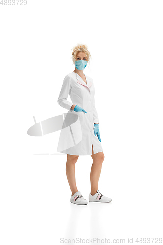 Image of Portrait of female doctor, nurse or cosmetologist in white uniform and blue gloves over white background