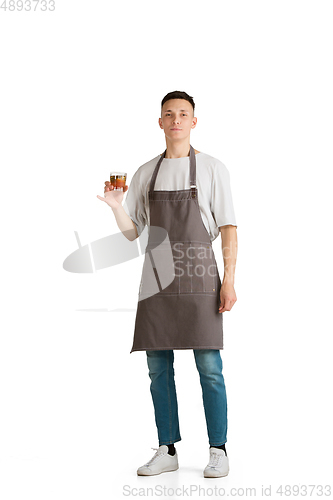 Image of Isolated portrait of a young male caucasian barista or bartender in brown apron smiling