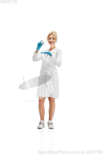 Image of Portrait of female doctor, nurse or cosmetologist in white uniform and blue gloves over white background