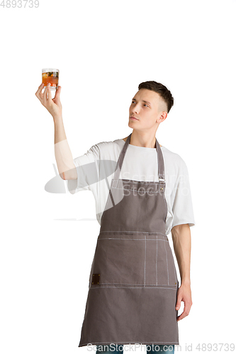 Image of Isolated portrait of a young male caucasian barista or bartender in brown apron smiling