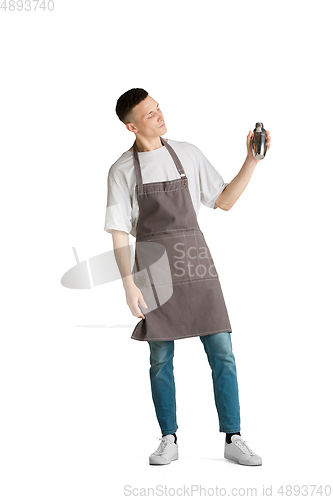 Image of Isolated portrait of a young male caucasian barista or bartender in brown apron smiling