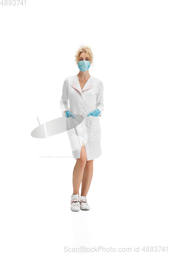 Image of Portrait of female doctor, nurse or cosmetologist in white uniform and blue gloves over white background