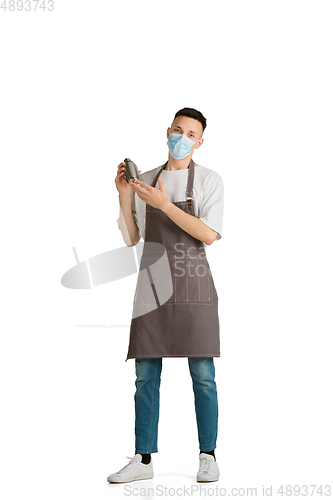 Image of Isolated portrait of a young male caucasian barista or bartender in brown apron smiling