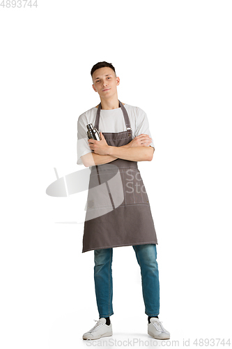 Image of Isolated portrait of a young male caucasian barista or bartender in brown apron smiling