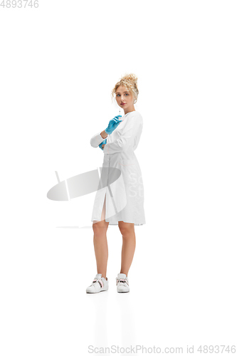 Image of Portrait of female doctor, nurse or cosmetologist in white uniform and blue gloves over white background