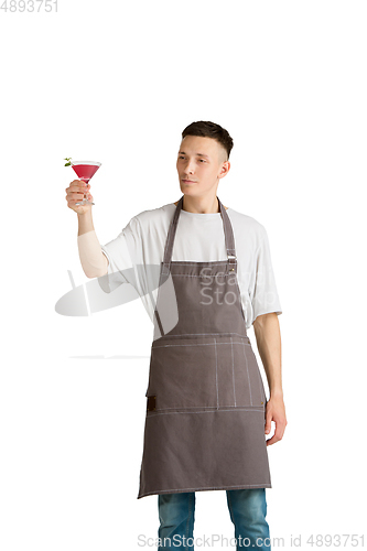 Image of Isolated portrait of a young male caucasian barista or bartender in brown apron smiling