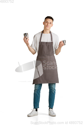 Image of Isolated portrait of a young male caucasian barista or bartender in brown apron smiling