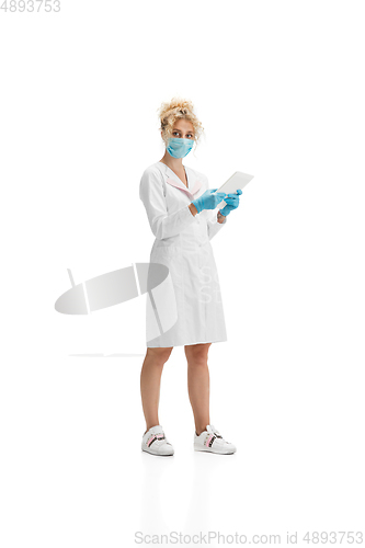 Image of Portrait of female doctor, nurse or cosmetologist in white uniform and blue gloves over white background