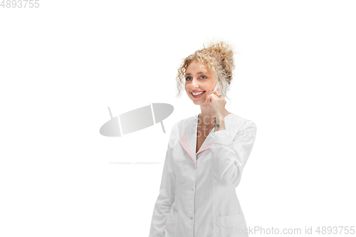 Image of Portrait of female doctor, nurse or cosmetologist in white uniform and blue gloves over white background