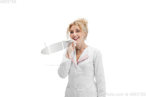 Image of Portrait of female doctor, nurse or cosmetologist in white uniform and blue gloves over white background
