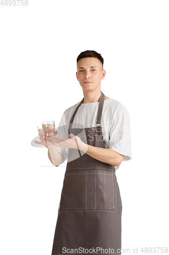 Image of Isolated portrait of a young male caucasian barista or bartender in brown apron smiling