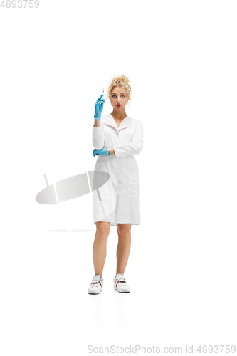 Image of Portrait of female doctor, nurse or cosmetologist in white uniform and blue gloves over white background