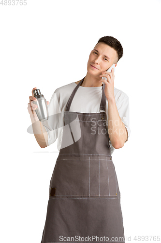 Image of Isolated portrait of a young male caucasian barista or bartender in brown apron smiling