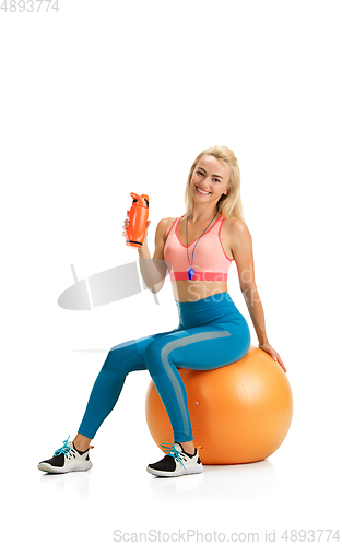 Image of Beautiful female fitness coach practicing isolated on white studio background