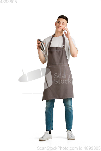 Image of Isolated portrait of a young male caucasian barista or bartender in brown apron smiling