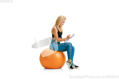 Image of Beautiful female fitness coach practicing isolated on white studio background