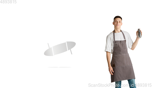 Image of Isolated portrait of a young male caucasian barista or bartender in brown apron smiling