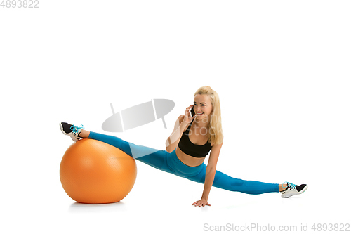 Image of Beautiful female fitness coach practicing isolated on white studio background