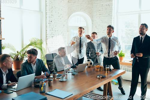 Image of Happy colleagues having fun in office while their colleagues working hard