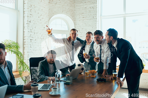 Image of Happy colleagues having fun in office while their colleagues working hard