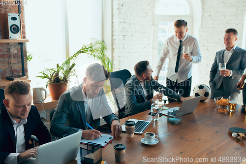 Image of Happy colleagues having fun in office while their colleagues working hard