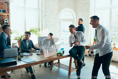 Image of Happy colleagues having fun in office while their colleagues working hard