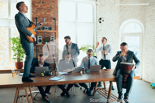 Image of Happy colleagues having fun in office while their colleagues working hard