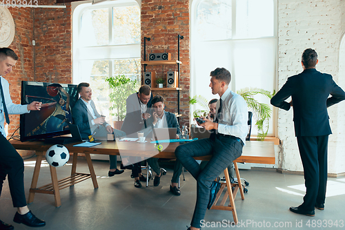 Image of Happy colleagues having fun in office while their colleagues working hard