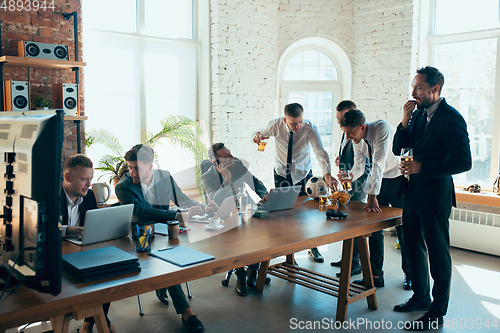 Image of Happy colleagues having fun in office while their colleagues working hard