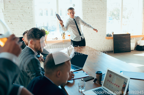 Image of Happy colleagues having fun in office while their colleagues working hard