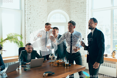 Image of Happy colleagues having fun in office while their colleagues working hard