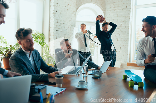 Image of Happy colleagues having fun in office while their colleagues working hard