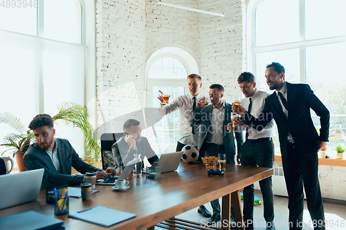 Image of Happy colleagues having fun in office while their colleagues working hard